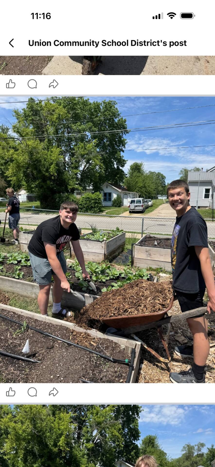 Students spread mulch around raised garden beds during a community service project.
