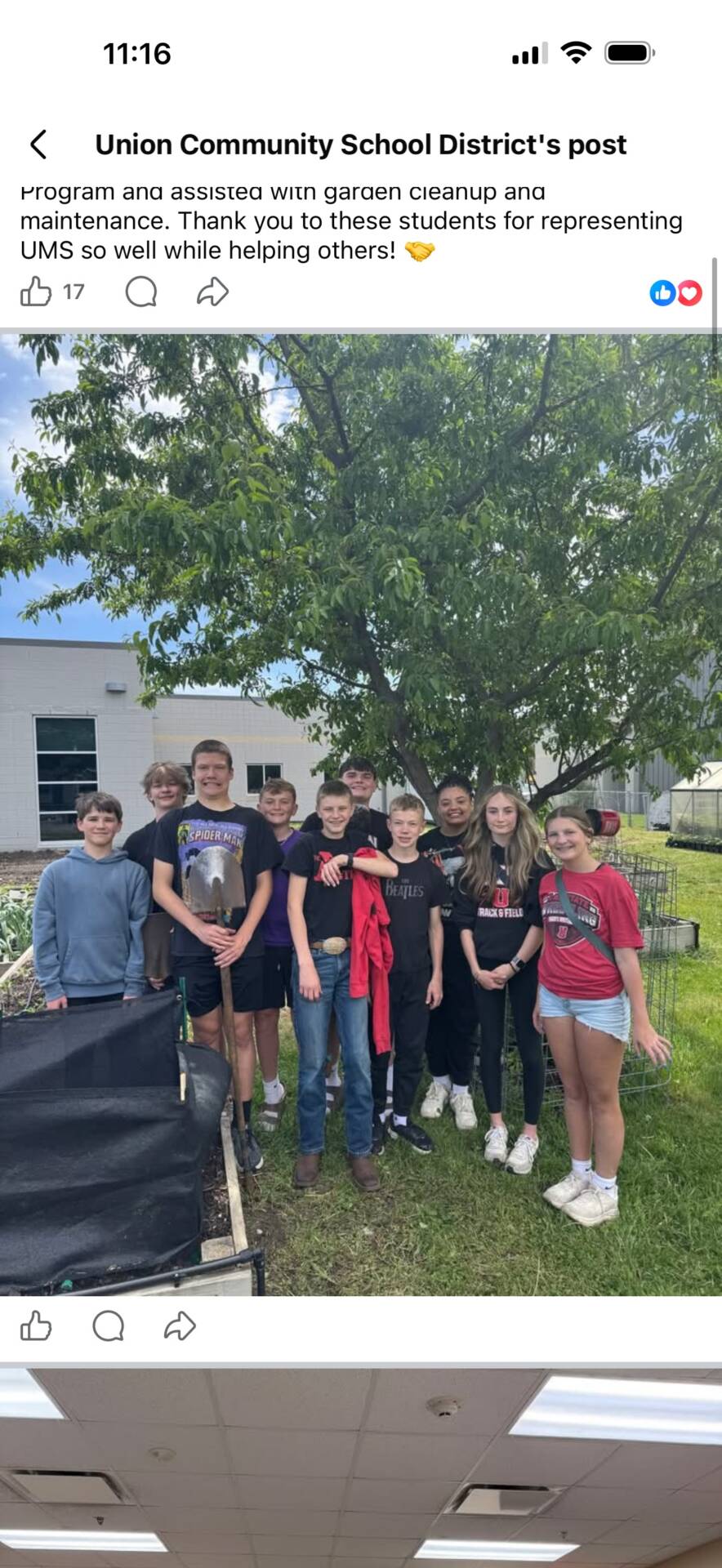 Middle school students pose together in a community garden after helping with cleanup and maintenance.