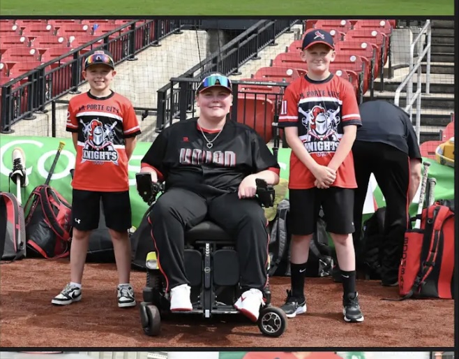 A Union baseball player in a wheelchair poses with two younger Porte City Knights players at Busch Stadium.