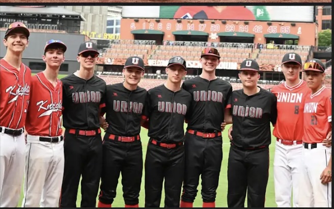 Union Knights baseball players pose together on the field at Busch Stadium in team uniforms.