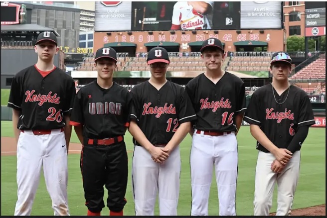 Five Union Knights baseball players stand on the field at Busch Stadium for a group photo.
