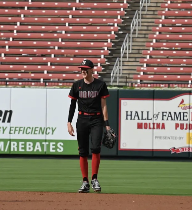 Union Knights baseball player stands in the outfield during a team event.