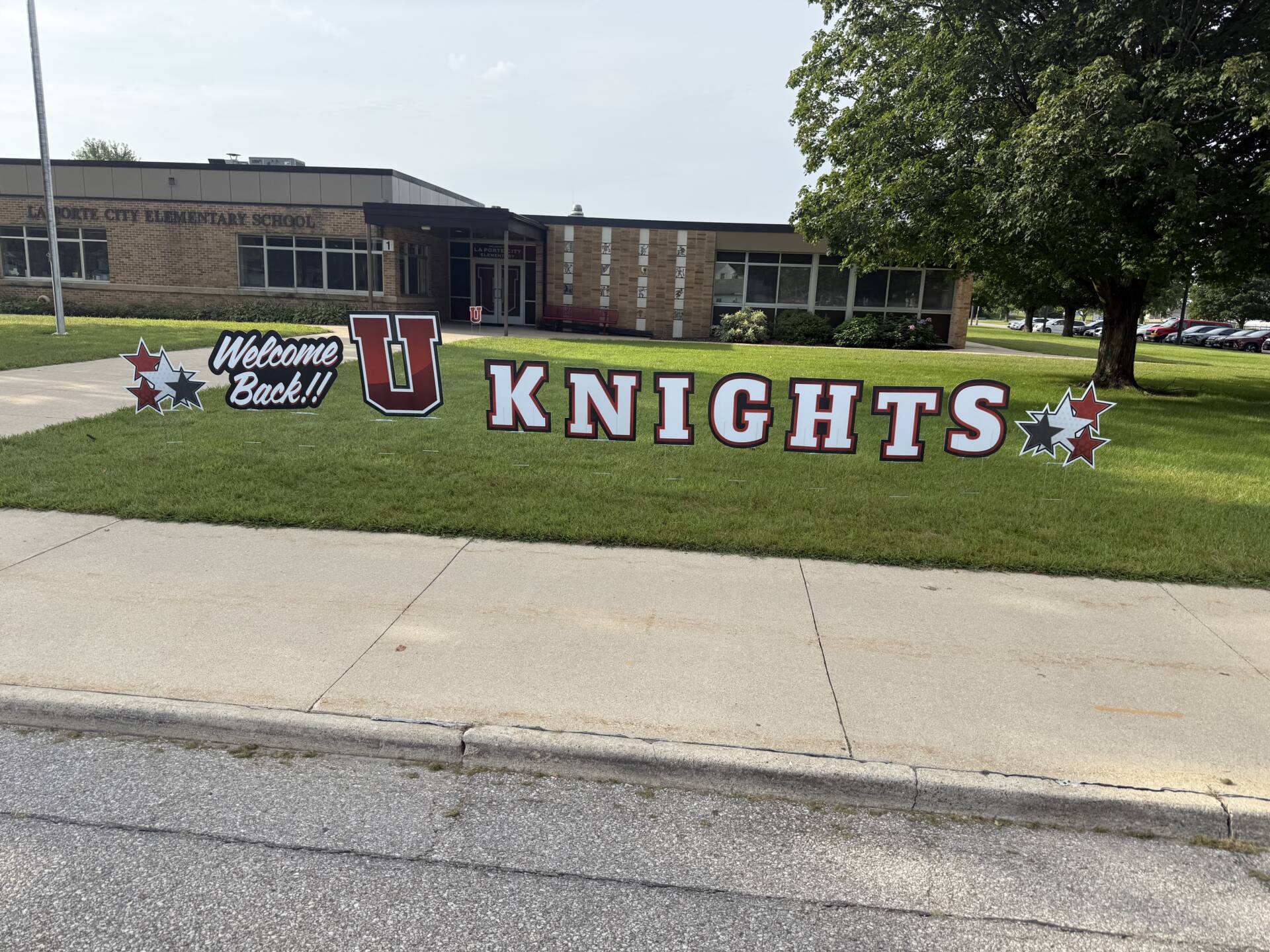 “Welcome Back!! U Knights” yard signs greet students outside.
