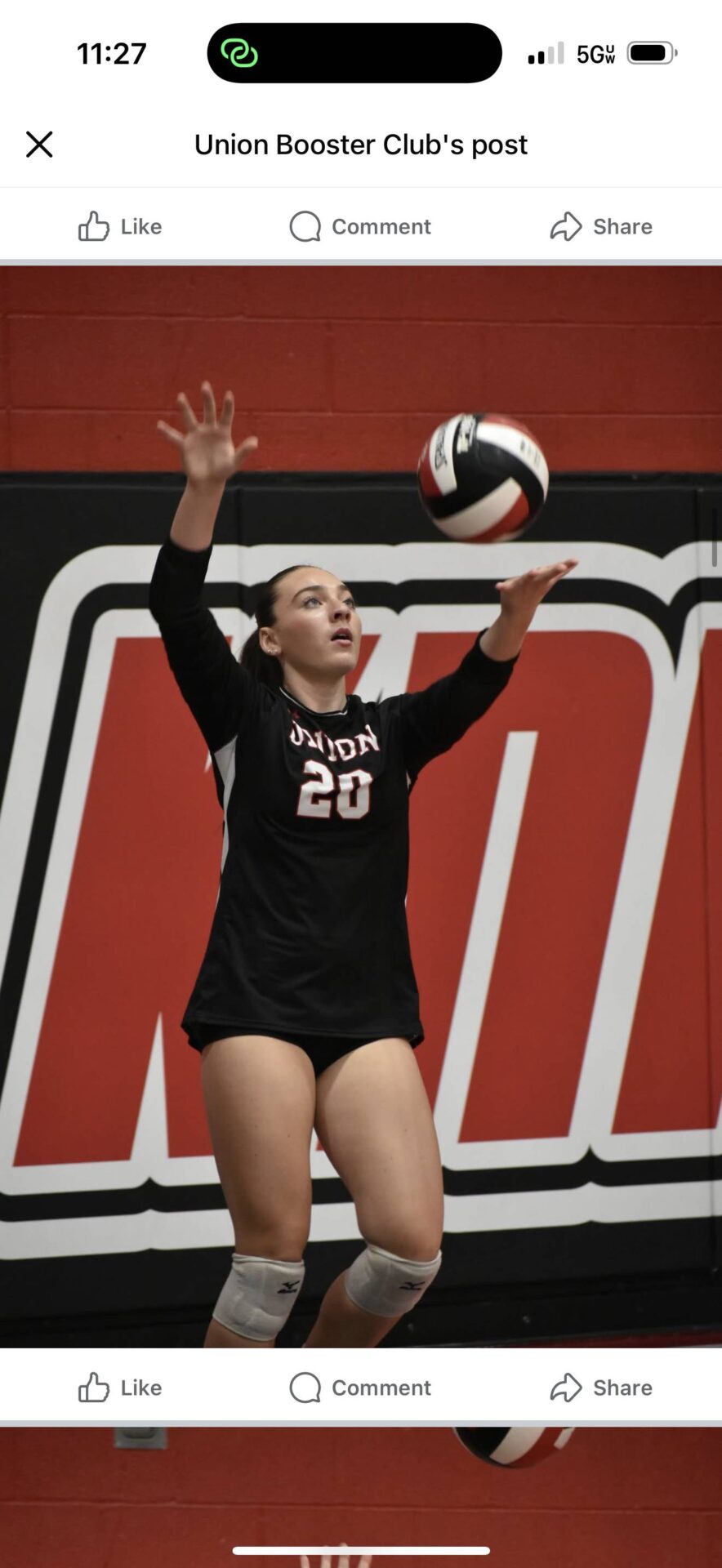 Volleyball player in a black Union Knights uniform prepares to serve the ball.