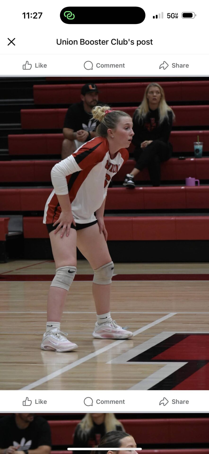 Player in red and white Union uniform crouches on the court, focused on play.