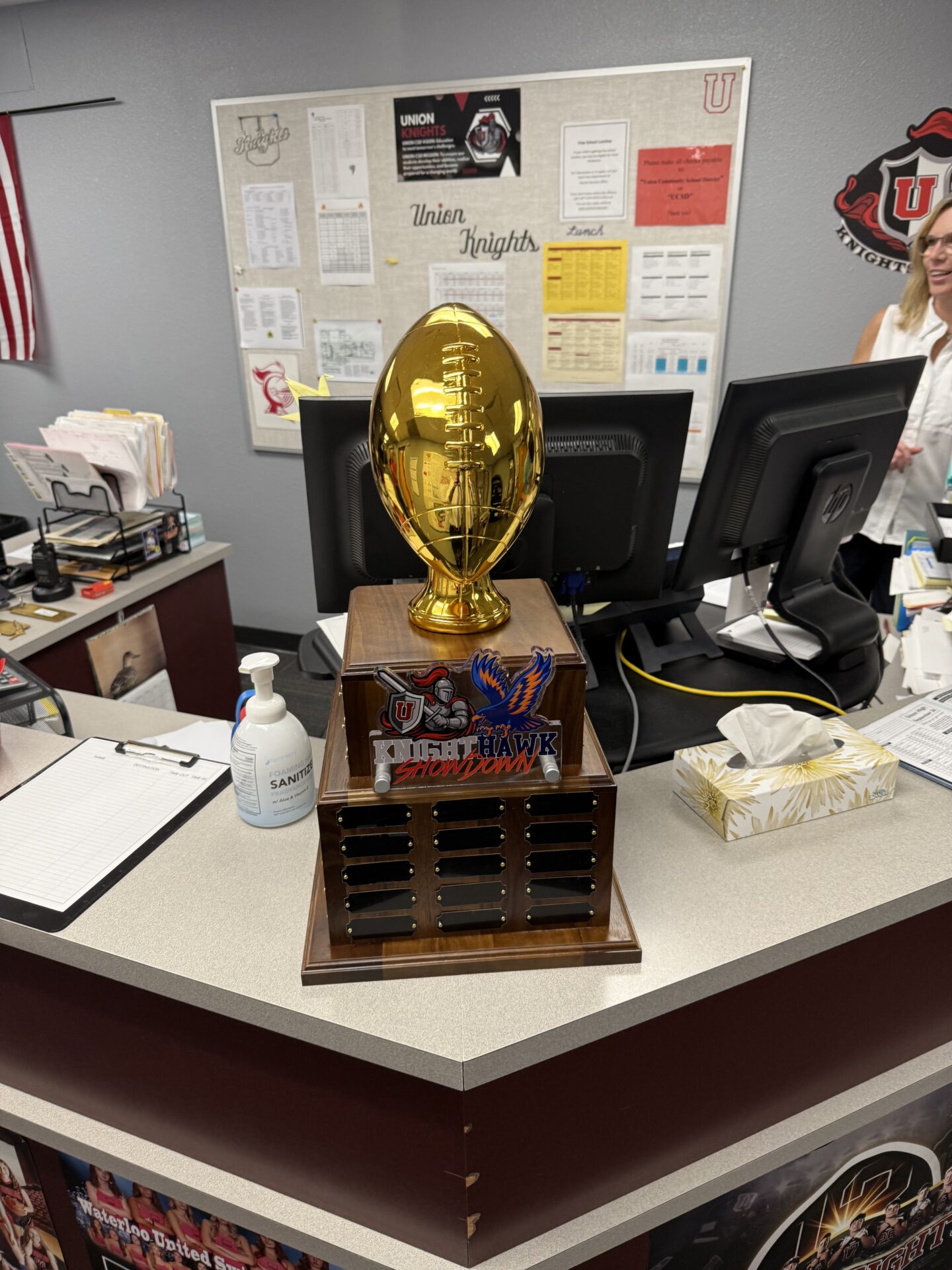 Knight Hawk Showdown golden football trophy on display in the office.